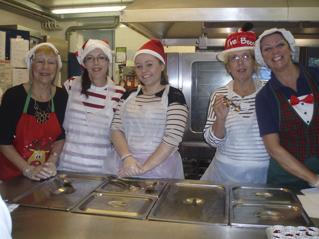 Volunteers in Christmas hats and aprons at The Saxon Day Centre